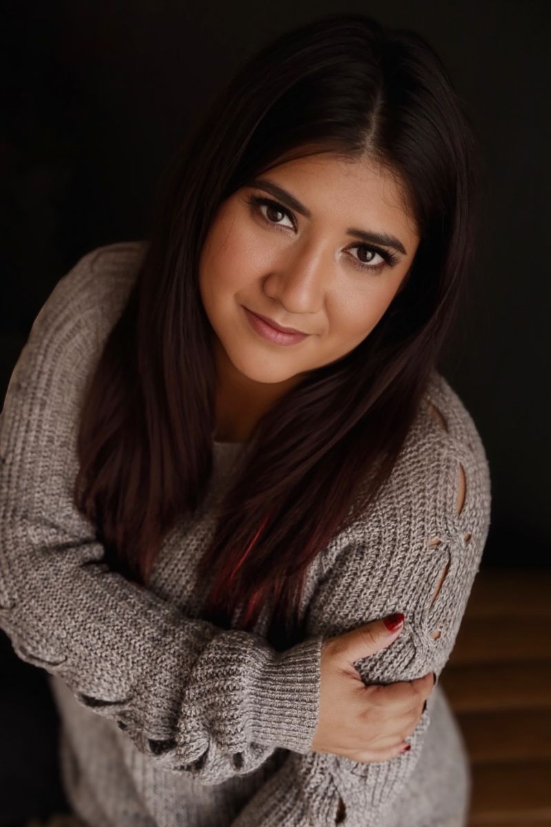 Karla Sanchez, LMT, looking up at camera and wearing a beige sweater.